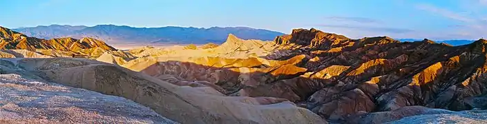 Lever du soleil sur Zabriskie Point avec, au milieu du panorama, Manly Beacon bien éclairé.