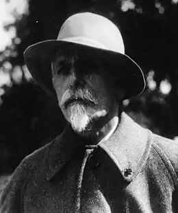 Portrait en noir et blanc d'un homme vêtu d'un chapeau.
