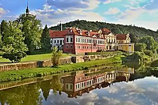 Photographie d'un château baroque se reflétant dans l'eau.