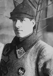 Photo noir et blanc d'un homme en uniforme posant le regard au loin, portant le numéro 39 au collet.