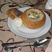 Żurek servi dans un pain creux et crème dans un oignon.