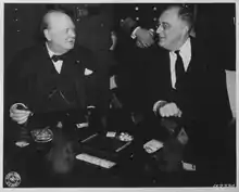 Roosevelt et Churchill à la conférence de Casablanca. Le Premier ministre britannique porte une veste par-dessus son gilet, une chaîne de montre en or et le nœud papillon de son père, et fume son habituel cigare.