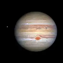 Jupiter occupe la majeure partie de l'image, sa grande tâche rouge au centre de l'image. Europe est visible à gauche de celle-ci.