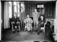 Photo d'archive en noir et blanc de quatre hommes assis.