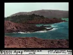 Photographie colorisée de 1937 : mer et roches rouges.