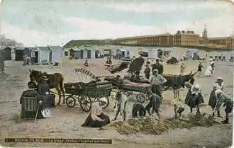 Ancienne photographie colorisée représentant un groupe d'enfants sur une plage